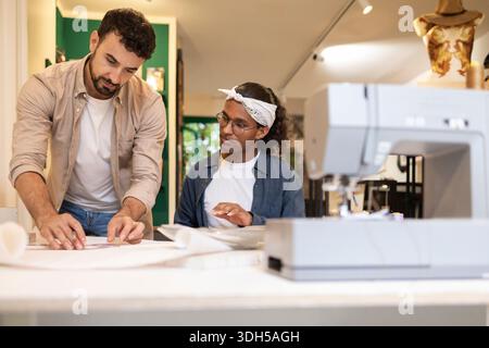 A diverse group of coworkers collaborating in a dynamic coworking space. The team is engaging in creative discussions, working together on shared proj Stock Photo