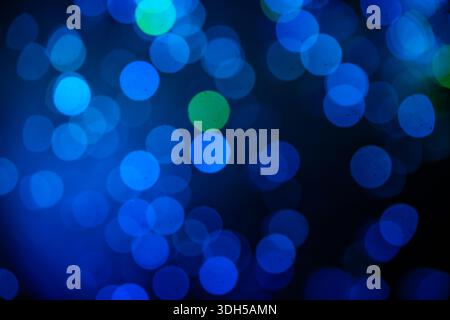 A captivating abstract composition featuring blue and green bokeh lights in various sizes. The lights create a stunning visual effect on a dark backgr Stock Photo