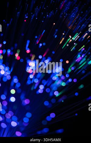A captivating display of fiber optic lights in vibrant blue, pink, and green hues. The abstract bokeh effect on a dark background evokes a sense of wo Stock Photo