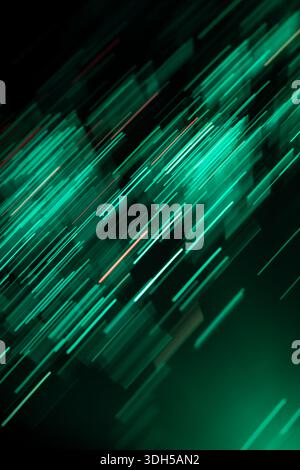 Dynamic diagonal streaks of green fiber optic lights create an abstract pattern on a dark background, evoking a sense of speed and technology Stock Photo
