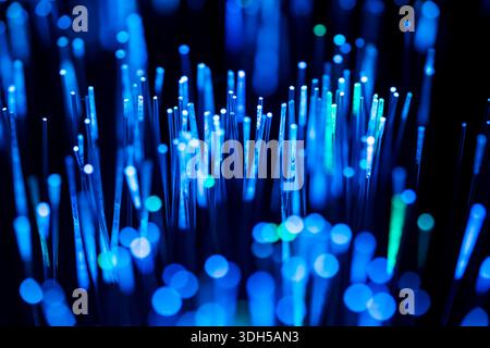 Blue fiber optics glow vibrantly, creating an abstract pattern of light. The close-up shot highlights the intricate design and displays a beautiful bo Stock Photo
