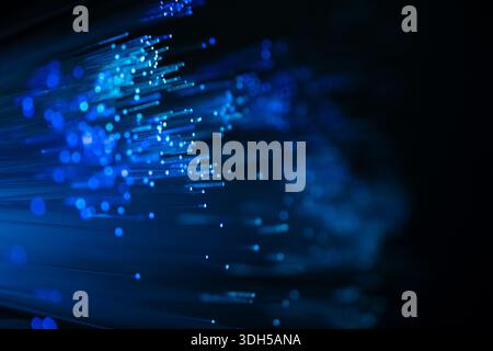 Blue fiber optic strands create a stunning abstract pattern against a dark background. Stock Photo