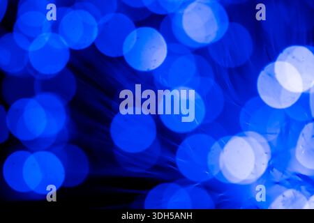A captivating abstract image featuring bright blue bokeh effects created by fiber optic lights. The blurred circles provide a dreamy, ethereal feel ag Stock Photo