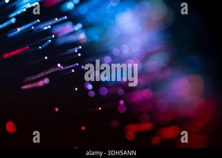 Abstract image featuring colorful fiber optic lights in red, blue, and purple. The vibrant bokeh effect on a dark background creates a captivating vis Stock Photo