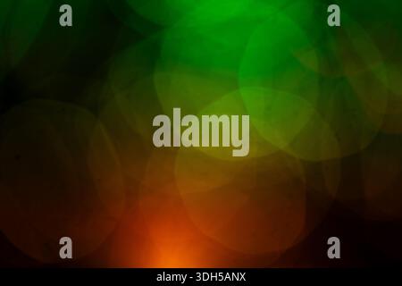 Abstract image featuring overlapping green and orange circular bokeh patterns on a dark background, creating a vibrant and dynamic visual experience r Stock Photo