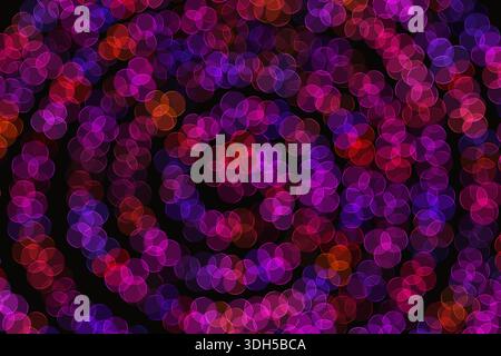 Abstract illustration featuring vibrant neon pink and purple circles creating a dynamic pattern. These colorful prints stand out against a deep black Stock Photo