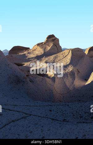 Rugged pumice stone formations catch the golden light of sunset at Campo de Piedra Pomez, Catamarca, Argentina, displaying a stunning, otherworldly vo Stock Photo
