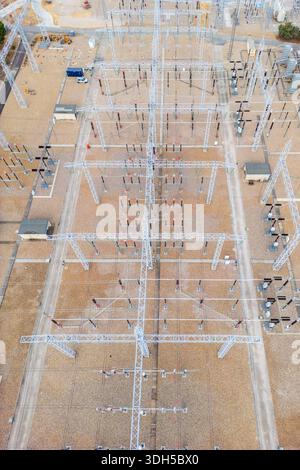 Aerial view of a metal electricity pylon standing in a dry, harvested ...