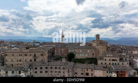 Drone view of an Italian historic city, showcasing ancient architecture and rooftops under a dramatic sky. Towering landmarks rise amidst the charming Stock Photo