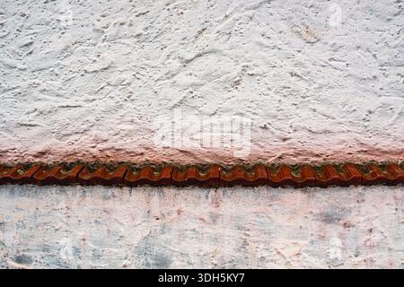 White Plastered Wall with Red Brick Detail and Rough Texture Stock Photo
