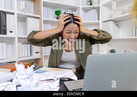 Stressed businesswoman dealing with heavy work pressure, reacting emotionally while reviewing reports and facing tight deadlines, highlighting workpla Stock Photo