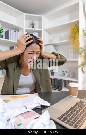Stressed businesswoman dealing with heavy work pressure, reacting emotionally while reviewing reports and facing tight deadlines, highlighting workpla Stock Photo