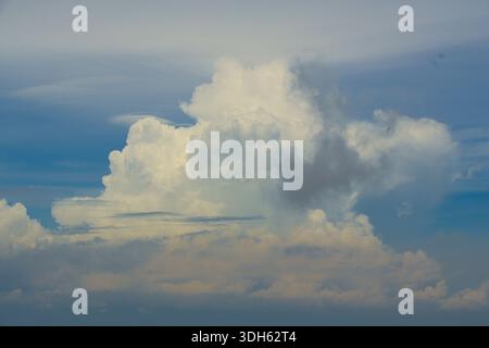 Dramatic white cumulus clouds against a vibrant blue sky. Natural weather formation ideal for background or texture. Stock Photo