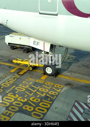 Karachi, Pakistan - January 05, 2026: Close up view of an aircraft nose landing gear parked on an airport apron with wheel chocks Stock Photo