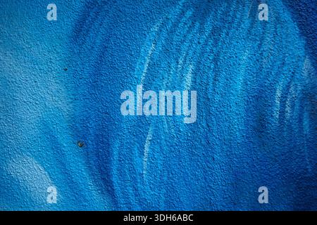 The texture of the wall facade painted with blue spray. Stock Photo