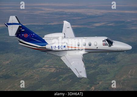 The Cessna 525 CitationJet M2 is a light corporate jet, registration YU-SCM, serial number 525-0918, with two Williams FJ44-1AP turbofan engines. Seating 5–7 passengers, it has a low wing, T-tail, and pressurized cabin. This close-up pilot image from Serbian Airpower 2025 highlights its glass cockpit, aerodynamic design, and flight controls. The M2 is optimized for short-range regional missions, corporate travel, and pilot training with efficient handling and structural integrity. Stock Photo