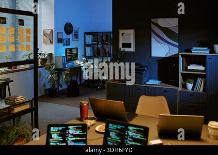 Empty Modern Office Showing Computer Screens Displaying Programming Code Stock Photo
