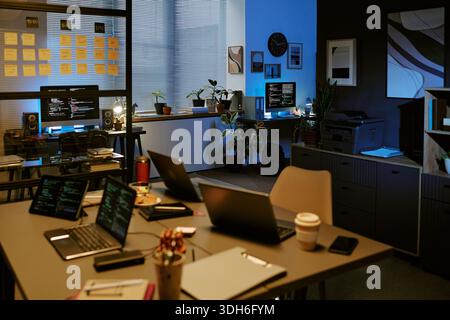 Empty Modern Office Showing Multiple Laptops and Monitors Displaying Code Stock Photo