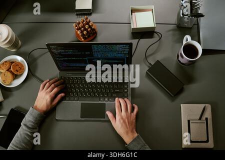 Caucasian Young Adult Man Coding on Laptop While Working at Office Desk Stock Photo