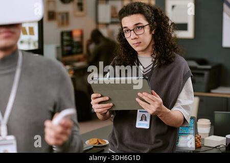 Young Adult Caucasian Man Using Digital Tablet during Office Meeting Stock Photo