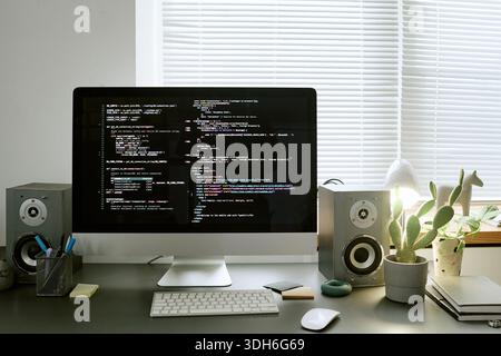 Modern Workspace Featuring Computer Monitor Displaying Programming Code Stock Photo