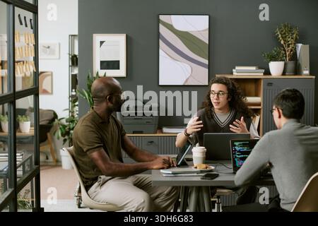 Multiethnic Young Adults Collaborating during Software Development Meeting Stock Photo
