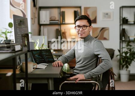 Portrait of Young Adult Caucasian Man Working on Laptop in Modern Office Stock Photo