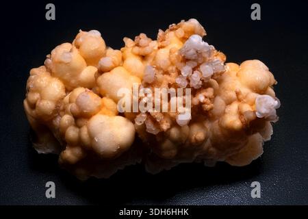 High resolution image of an aragonite stone featuring bubbly textures and small translucent crystals reflecting light on a dark surface Stock Photo