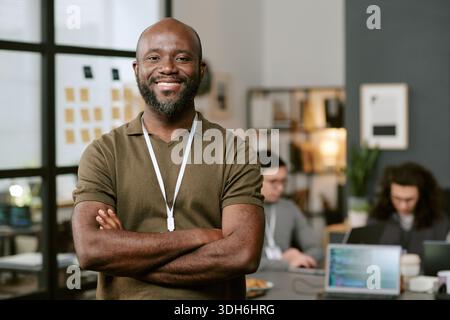 Portrait of Young Black Man Smiling Confidently in Modern Office Stock Photo