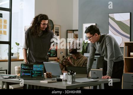 Multiethnic Young Adult Men Collaborating on Software Development Project Stock Photo
