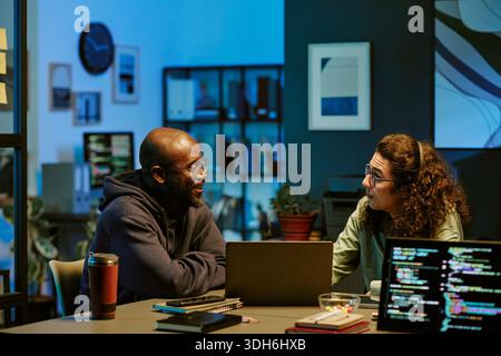 Young Adult Black Man and Young Adult Caucasian Man Collaborating in Office Stock Photo