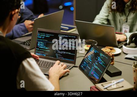 Young Adult Men and Women Collaborating on Software Development Project Indoors Stock Photo