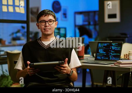 Portrait of Young Adult Caucasian Man Using Digital Tablet in Modern Office Stock Photo