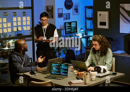 Multiethnic Young Adults Collaborating on Software Development Project in Office Stock Photo