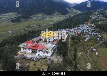 Aerial view of Gangtey Monastery standing proudly against the backdrop of lush green valleys and traditional Bhutanese architecture, Gangtey Monastery Stock Photo