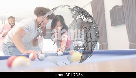 Leaning woman in red top aiming cue on blue-felt pool table at home, group watching globe Stock Photo