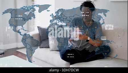 Writing woman in striped top, dark pants on home sofa with tablet, pen, data overlay Stock Photo