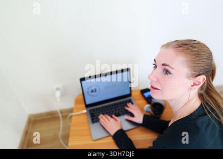 Young woman work on laptop displaying artificial intelligence modern work lifestyle Stock Photo