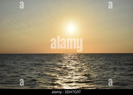 The incredible view of the ocean with the sunset in the sky Stock Photo