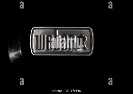 VINKOVCI, CROATIA, 11.16.2025:A close-up of the Weber metal logo badge set against a black background. This glossy, industrial emblem conveys durabili Stock Photo
