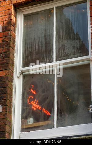 Illuminated neon sign 'the coffee room' behind window covered in condensation in a first-floor coffee shop, mysterious view through window into cafe. Stock Photo