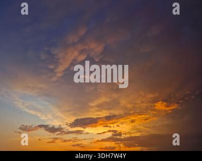 Expansive view of a dramatic sunset sky filled with textured mammatus and altocumulus clouds. Breathtaking natural scene with the horizon glowing in f Stock Photo