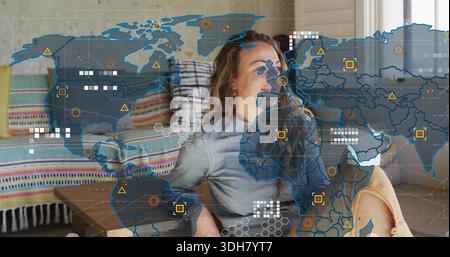 Leaning back adult woman wearing light-gray top and tan shorts at home, viewing AR map overlay Stock Photo