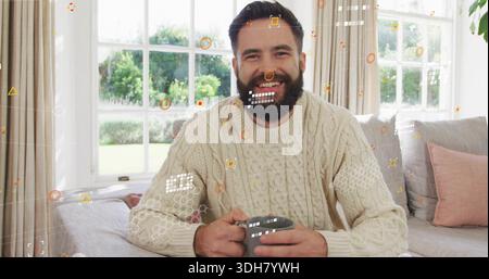 Sitting bearded man wearing cream cable-knit sweater holding gray mug in living room, HUD overlays Stock Photo