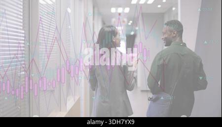 Walking two colleagues talking and gesturing in glass-walled corridor, blazers, candlestick overlay Stock Photo