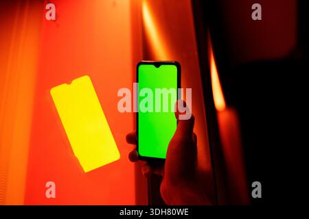 man's hand showing cell phone screen to camera at night in exteriors Stock Photo