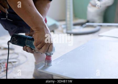 hands of latin worker drilling holes in tile Stock Photo