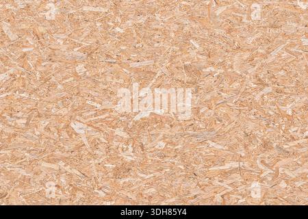 High resolution macro of an OSB panel made of pressed wood flakes. Natural wooden texture background for construction, interior design, and industrial Stock Photo
