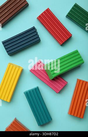 Multi-colored plasticine bricks on blue background. Childrens plasticine close-up. Stock Photo