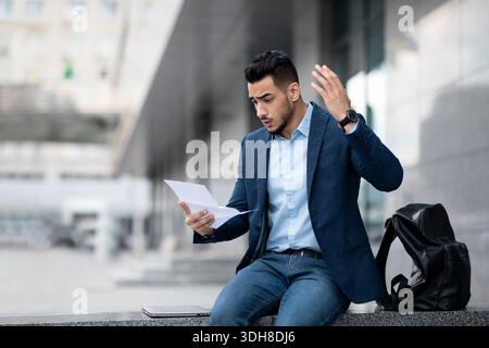 Emotional arabic guy young entrepreneur reading mail, copy space Stock Photo